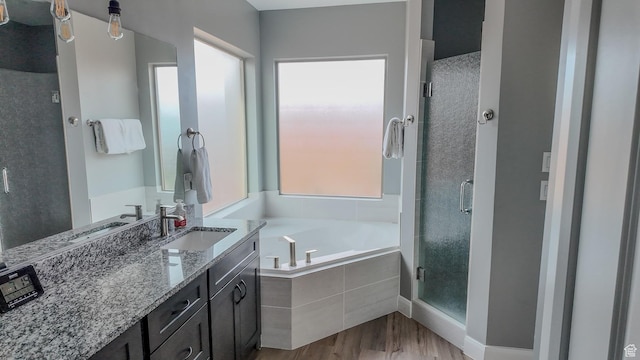 full bathroom with a bath, plenty of natural light, wood finished floors, and a stall shower