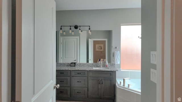 bathroom featuring double vanity, a sink, and a garden tub