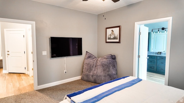 bedroom with light colored carpet, connected bathroom, and baseboards