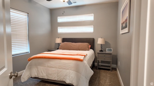 carpeted bedroom with visible vents, baseboards, and a ceiling fan