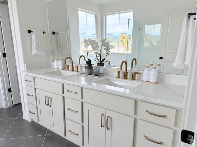 bathroom with a stall shower, tile patterned floors, and double vanity