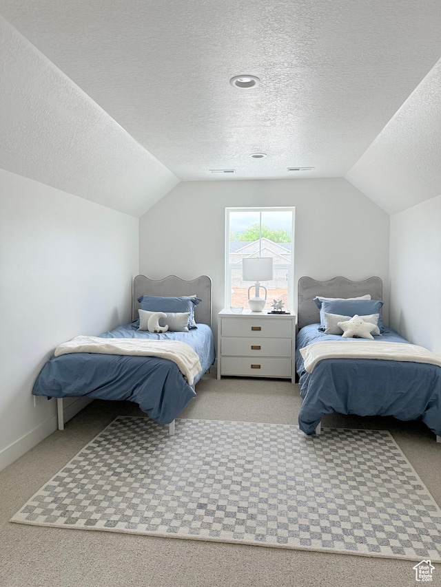 carpeted bedroom featuring vaulted ceiling, a textured ceiling, and baseboards
