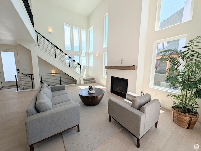 6967 W Lake Ave S Unit 324, South Jordan, UT 84009 - living area with a towering ceiling, wood finished floors, stairs, and a fireplace