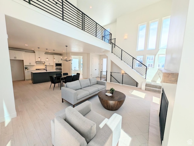 6967 W Lake Ave S Unit 324, South Jordan, UT 84009 - living area featuring light wood-style flooring, stairway, recessed lighting, and a high ceiling