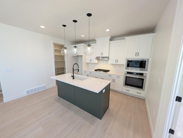 kitchen with a sink, light wood-style floors, white cabinetry, visible vents, and appliances with stainless steel finishes