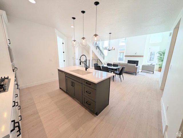 6967 W Lake Ave S Unit 324, South Jordan, UT 84009 - kitchen with a sink, stainless steel appliances, light countertops, a chandelier, and a fireplace