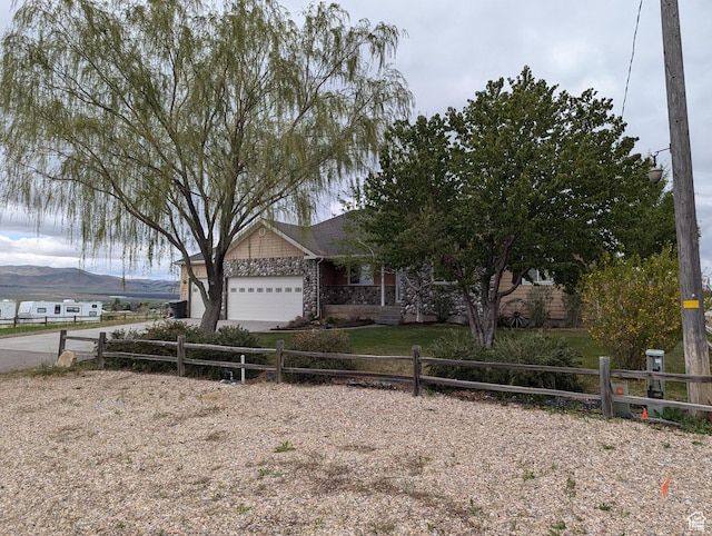 565 E Platt Ln Unit 1, Mona, UT 84645 - ranch-style house featuring concrete driveway, stone siding, a garage, and fence private yard