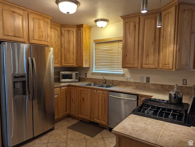 565 E Platt Ln Unit 1, Mona, UT 84645 - kitchen with a sink, a textured ceiling, tile countertops, light tile patterned floors, and appliances with stainless steel finishes