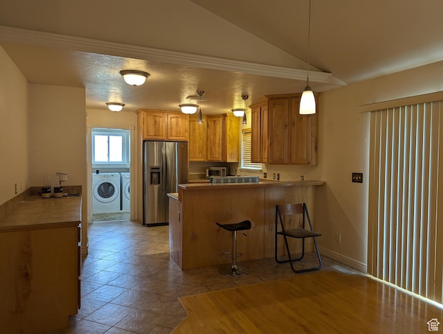 565 E Platt Ln Unit 1, Mona, UT 84645 - kitchen with a peninsula, lofted ceiling, a breakfast bar area, separate washer and dryer, and stainless steel fridge with ice dispenser