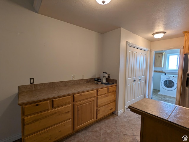 565 E Platt Ln Unit 1, Mona, UT 84645 - clothes washing area featuring washer / clothes dryer, laundry area, light tile patterned flooring, a textured ceiling, and baseboards