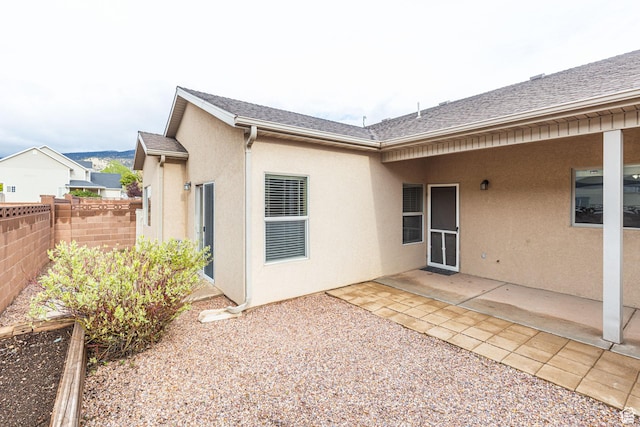 396 W 1500 N, Enoch, UT 84721 - rear view of property with stucco siding, roof with shingles, fence, and a patio