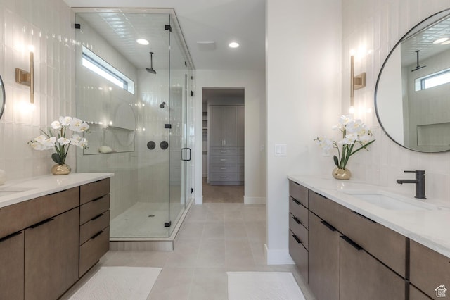 full bathroom featuring a stall shower, tile patterned floors, baseboards, backsplash, and vanity