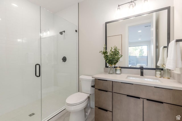 bathroom featuring vanity, toilet, and a shower stall