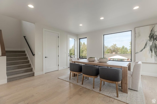 dining space featuring baseboards, light wood-style flooring, and recessed lighting