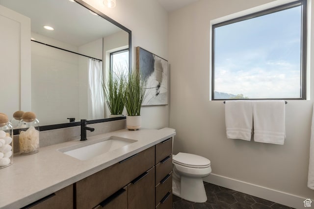 full bath with toilet, baseboards, a healthy amount of sunlight, and vanity