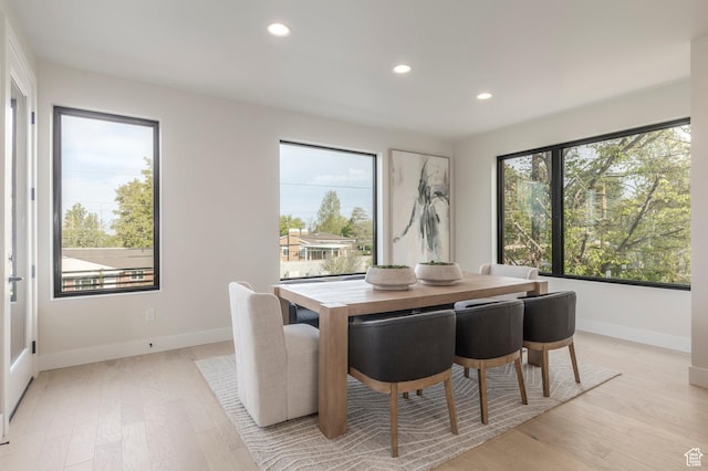 dining space featuring baseboards, light wood-type flooring, and recessed lighting
