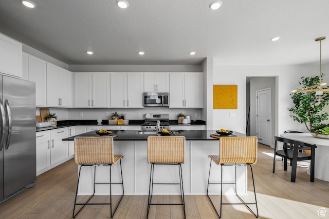 kitchen featuring stainless steel appliances, dark countertops, and white cabinets