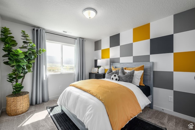 bedroom with baseboards, a textured ceiling, visible vents, and light colored carpet