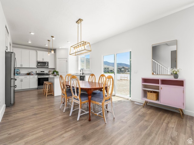 dining space featuring baseboards, recessed lighting, and wood finished floors