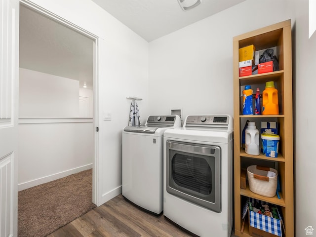 laundry area with washer and clothes dryer, laundry area, baseboards, and wood finished floors