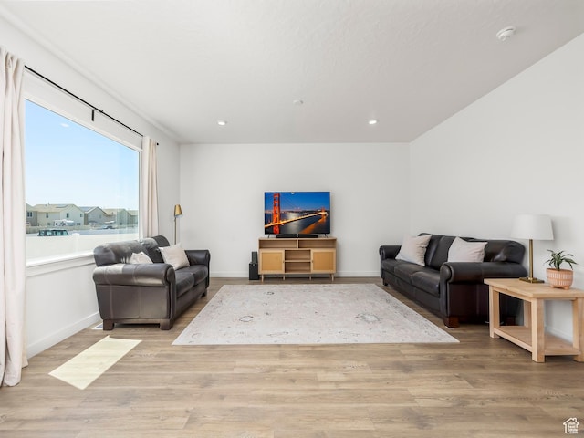 living room with baseboards, light wood finished floors, and recessed lighting