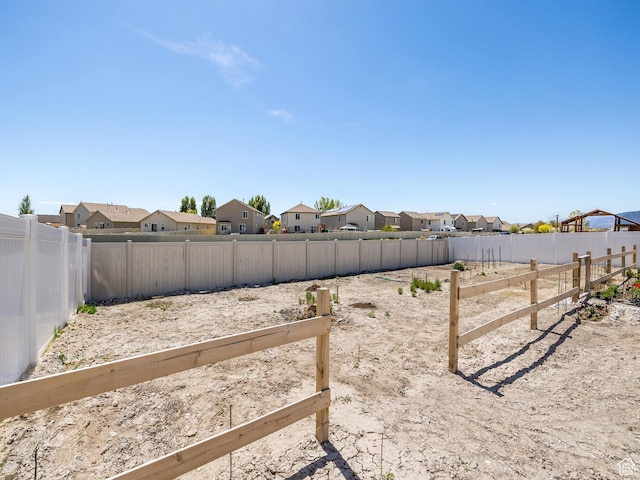view of yard featuring a fenced backyard and a residential view