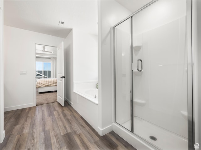 full bathroom with wood finished floors, baseboards, a stall shower, connected bathroom, and a garden tub