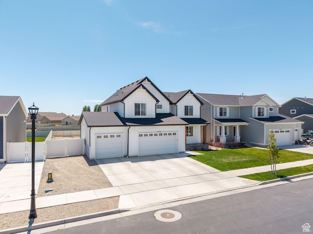 view of front of home featuring board and batten siding, fence, an attached garage, a residential view, and concrete driveway