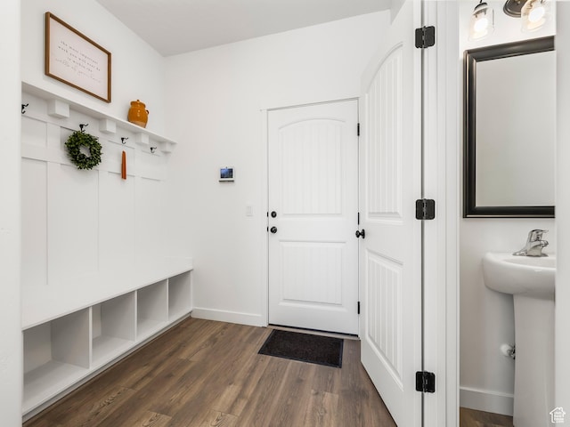 mudroom with baseboards, a sink, and dark wood-style floors