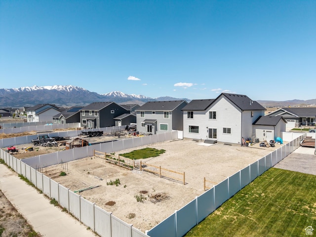 exterior space with a residential view, a mountain view, and a fenced backyard
