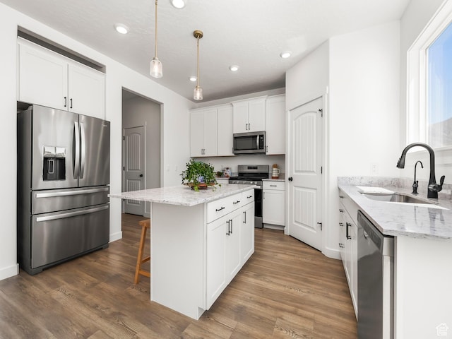 kitchen with a center island, a sink, white cabinetry, appliances with stainless steel finishes, and recessed lighting