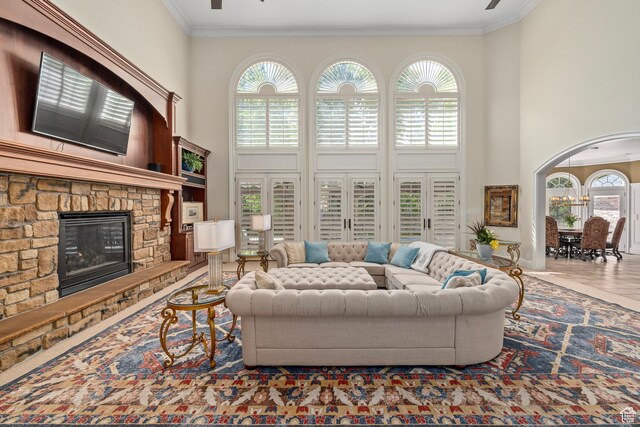 2428 E Field Rose Dr, Holladay, UT 84121 - living room with ornamental molding, a towering ceiling, and a stone fireplace