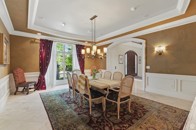 2428 E Field Rose Dr, Holladay, UT 84121 - dining space with an inviting chandelier, wainscoting, a decorative wall, arched walkways, and a raised ceiling