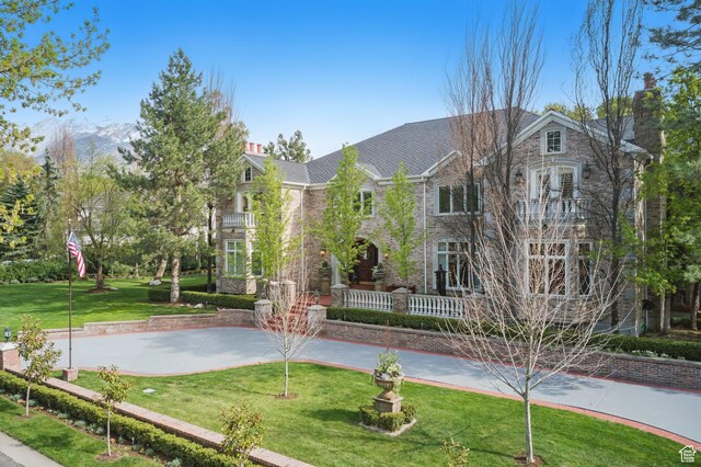 2428 E Field Rose Dr, Holladay, UT 84121 - view of front facade with a front lawn, a chimney, stone siding, and a balcony