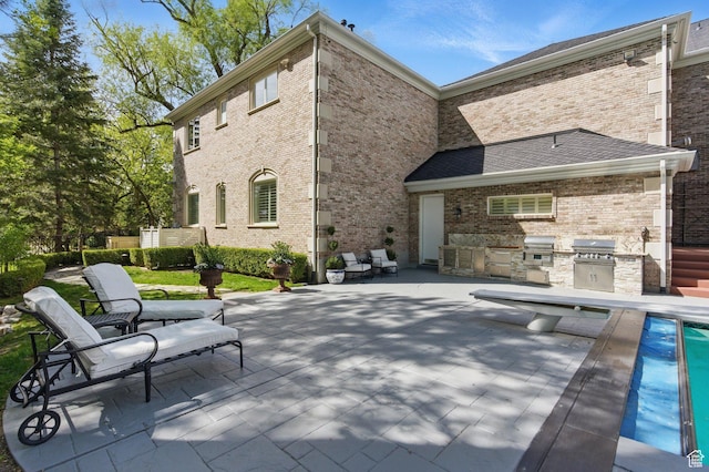 2428 E Field Rose Dr, Holladay, UT 84121 - rear view of house featuring exterior kitchen, a patio, and brick siding