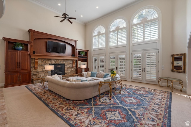 2428 E Field Rose Dr, Holladay, UT 84121 - living room with light colored carpet, a towering ceiling, crown molding, a ceiling fan, and a stone fireplace