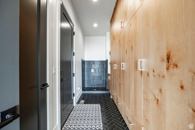 hall featuring recessed lighting, dark tile patterned floors, and baseboards