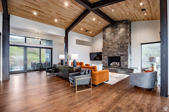 living area with hardwood / wood-style flooring, wood ceiling, a fireplace, high vaulted ceiling, and beam ceiling