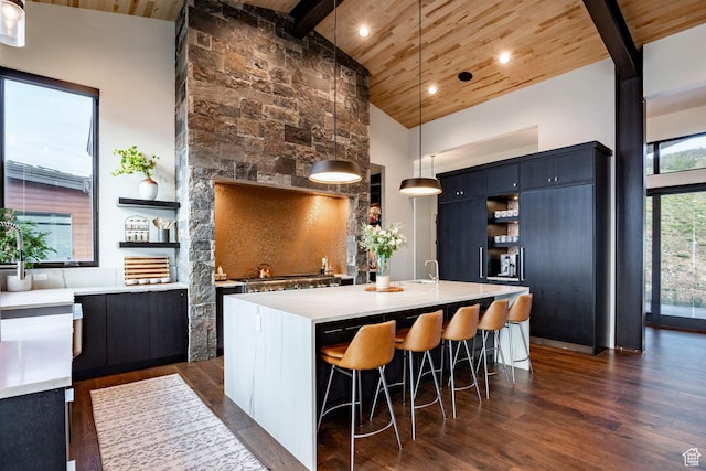kitchen with open shelves, wood ceiling, high vaulted ceiling, light countertops, and a kitchen breakfast bar