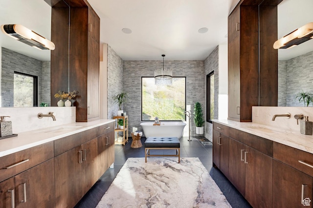 bathroom with two vanities, a freestanding bath, and tile patterned floors