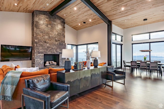 living area with wood ceiling, wood finished floors, beam ceiling, high vaulted ceiling, and a fireplace
