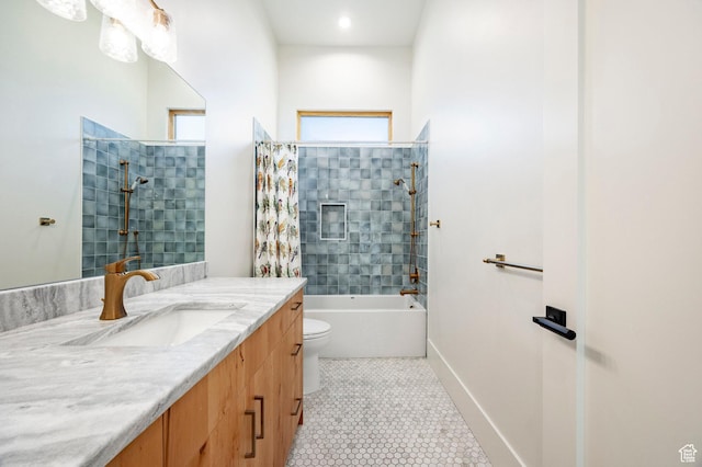 bathroom featuring toilet, vanity, tile patterned floors, bathing tub / shower combination, and baseboards