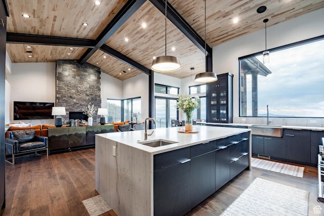 kitchen with a sink, modern cabinets, wood ceiling, dark wood-type flooring, and an island with sink