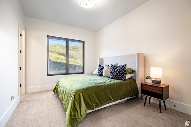 bedroom featuring light carpet and baseboards