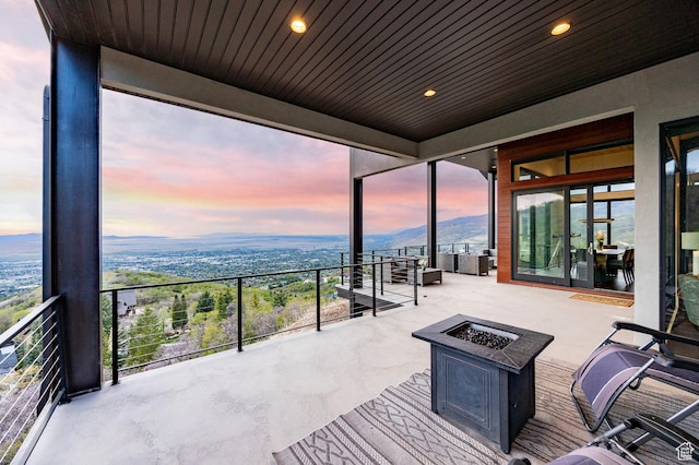 view of patio with a fire pit and a mountain view