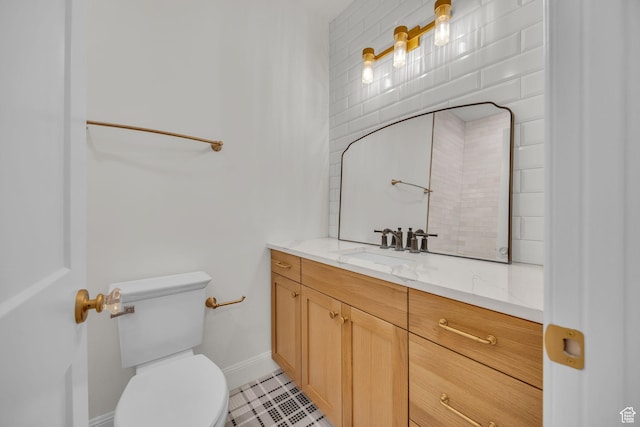 bathroom featuring toilet, baseboards, vanity, and tile patterned flooring