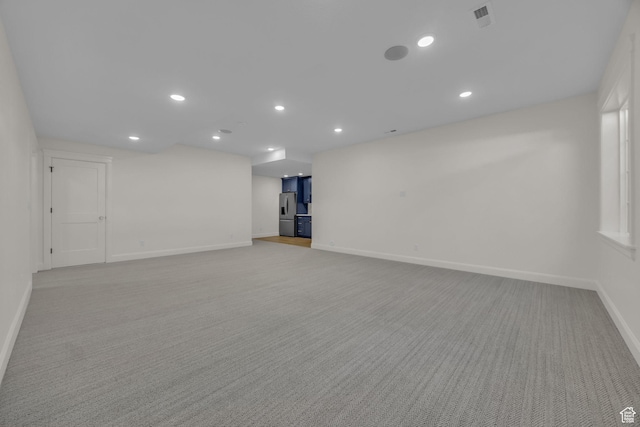 interior space with baseboards, visible vents, recessed lighting, and light colored carpet