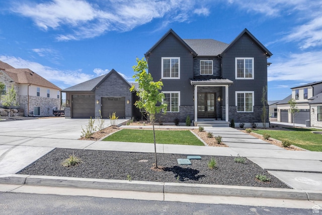 view of front of property featuring an attached garage, french doors, brick siding, concrete driveway, and cooling unit