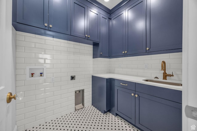 clothes washing area featuring cabinet space, hookup for a washing machine, electric dryer hookup, and a sink