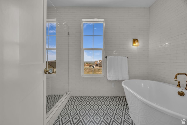 bathroom featuring a shower stall, tile patterned floors, and a freestanding bath